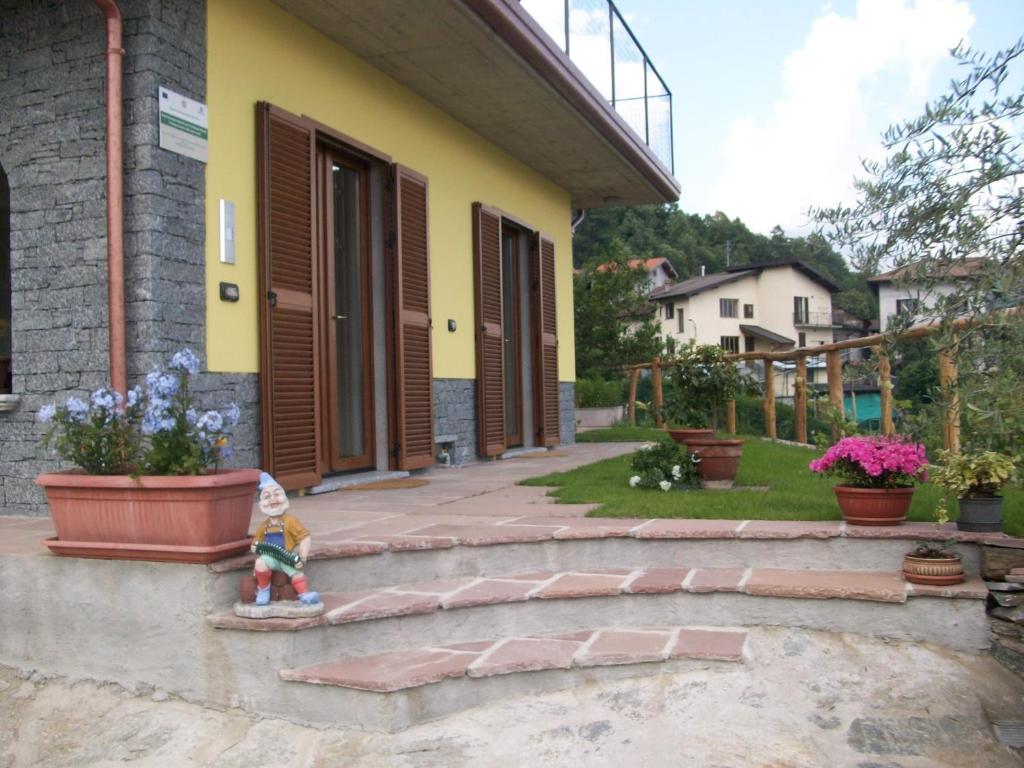 mała figurka stojąca przed domem w obiekcie Agriturismo Botton D'Oro w mieście Dongo