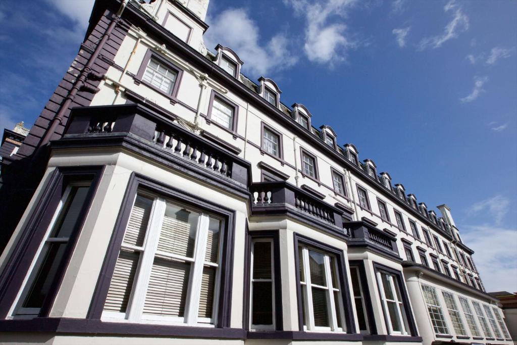 a large building with white windows and a blue sky at Carlisle Station Hotel, Sure Hotel Collection by BW in Carlisle