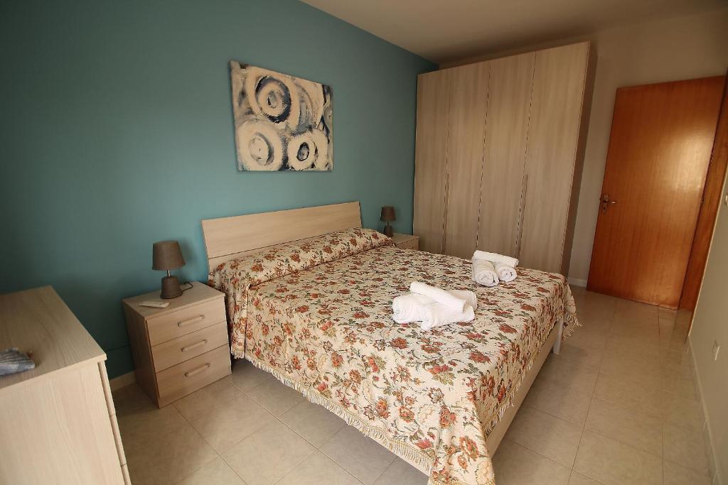 a bedroom with a bed with two towels on it at Sabbia e Mare in Torre San Giovanni Ugento