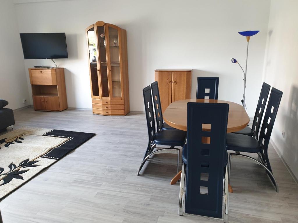 comedor con mesa, sillas y TV en Osterbrock EG Monteurwohnung, en Geeste