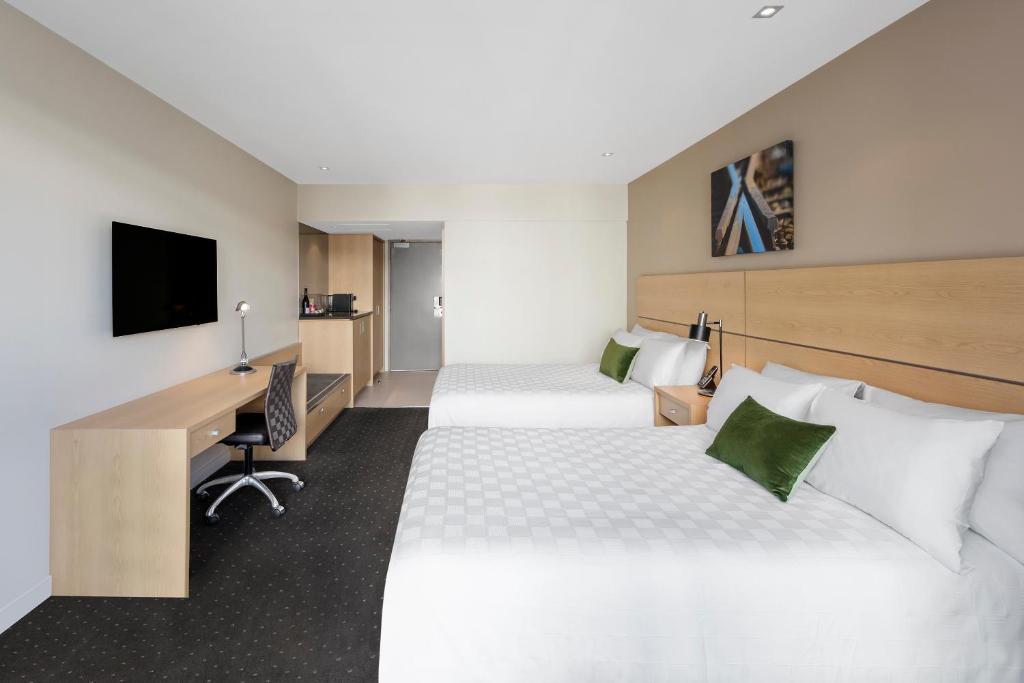 
a hotel room with two beds and a television at Crowne Plaza Queenstown, an IHG Hotel in Queenstown
