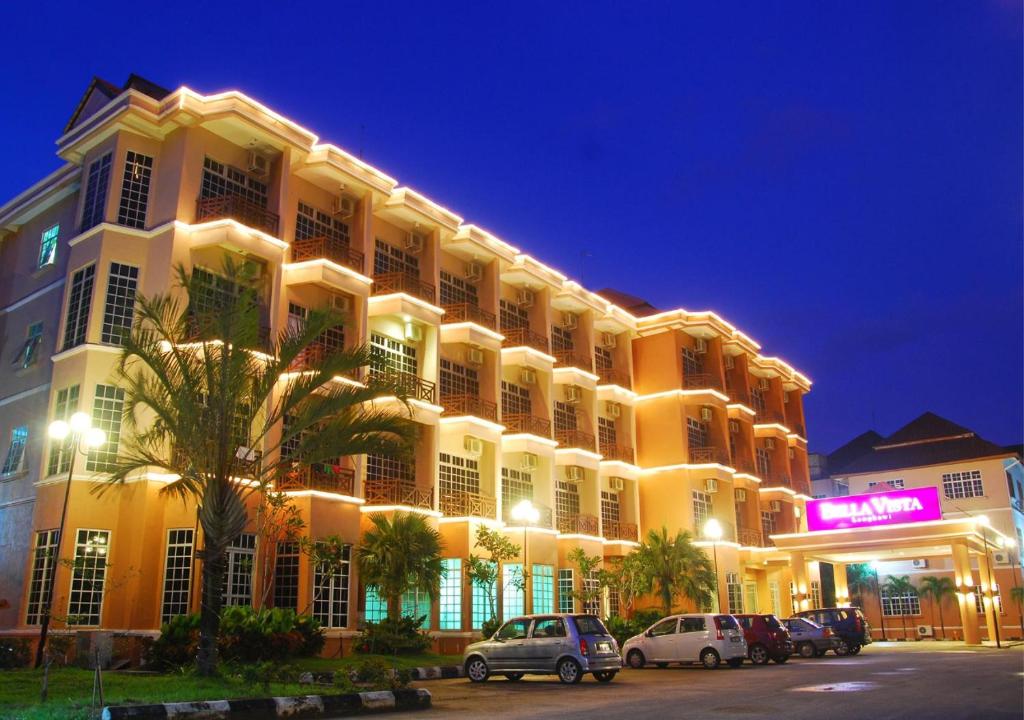 ein großes Gebäude mit Autos auf einem Parkplatz in der Unterkunft Bella Vista Express Hotel in Pantai Cenang