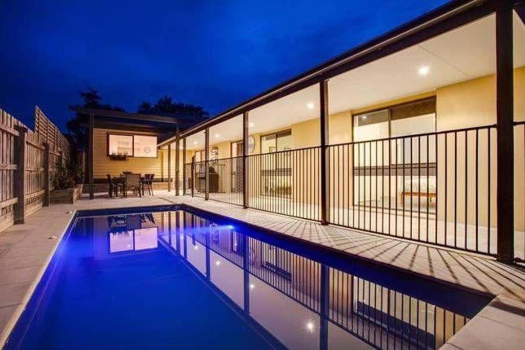 a swimming pool in front of a building at night at Charmes, paradise by the shore in Tootgarook
