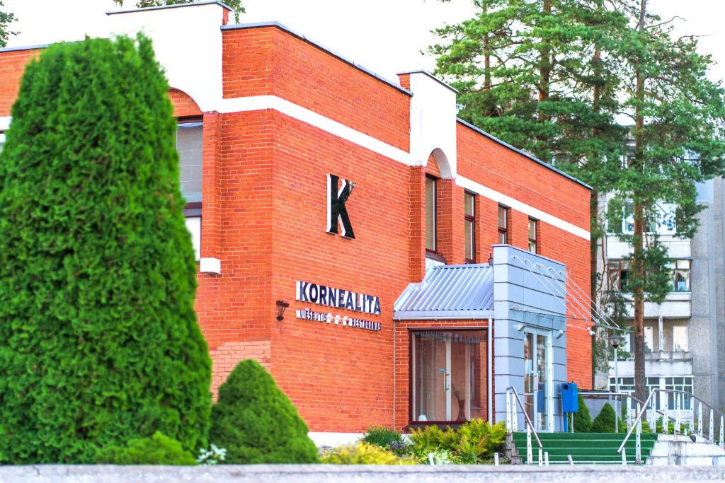 a red brick building with a kowment sign on it at Kornealita in Visaginas