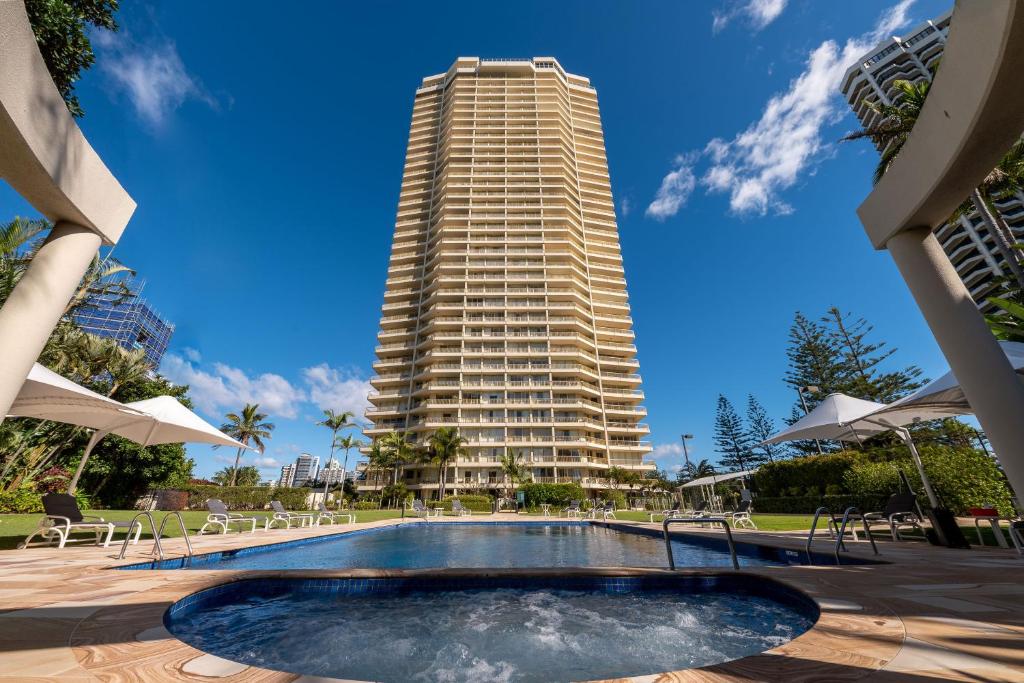 a tall building with a swimming pool in front of a building at Contessa Holiday Apartments in Gold Coast