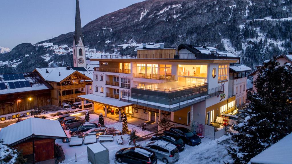 ヴェンスにあるKinderhotel Stefanの駐車場に車が駐車されている大きな建物