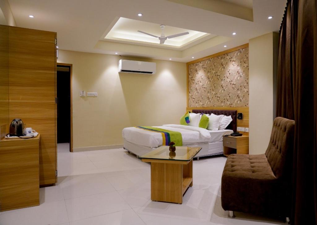 a hotel room with a bed and a chair at Click Hotel Capital House in Patna