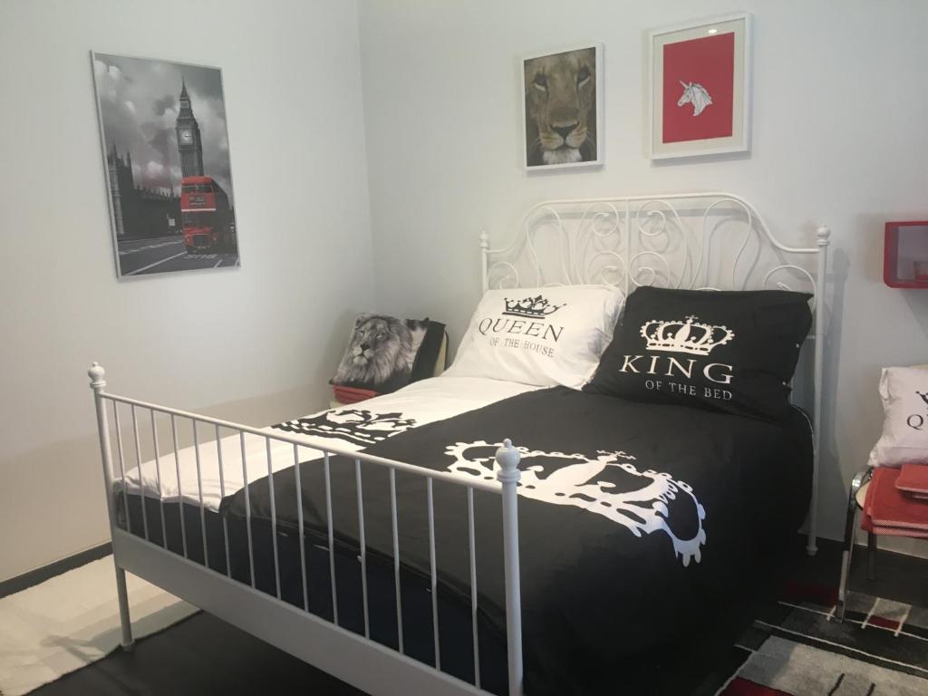 a bedroom with a bed with black and white pillows at Buckingham Palace Apartman, Debrecen in Debrecen