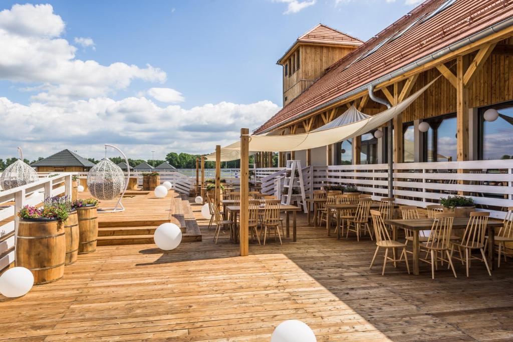 a patio with tables and chairs on a building at Hotel Naturum in Milicz