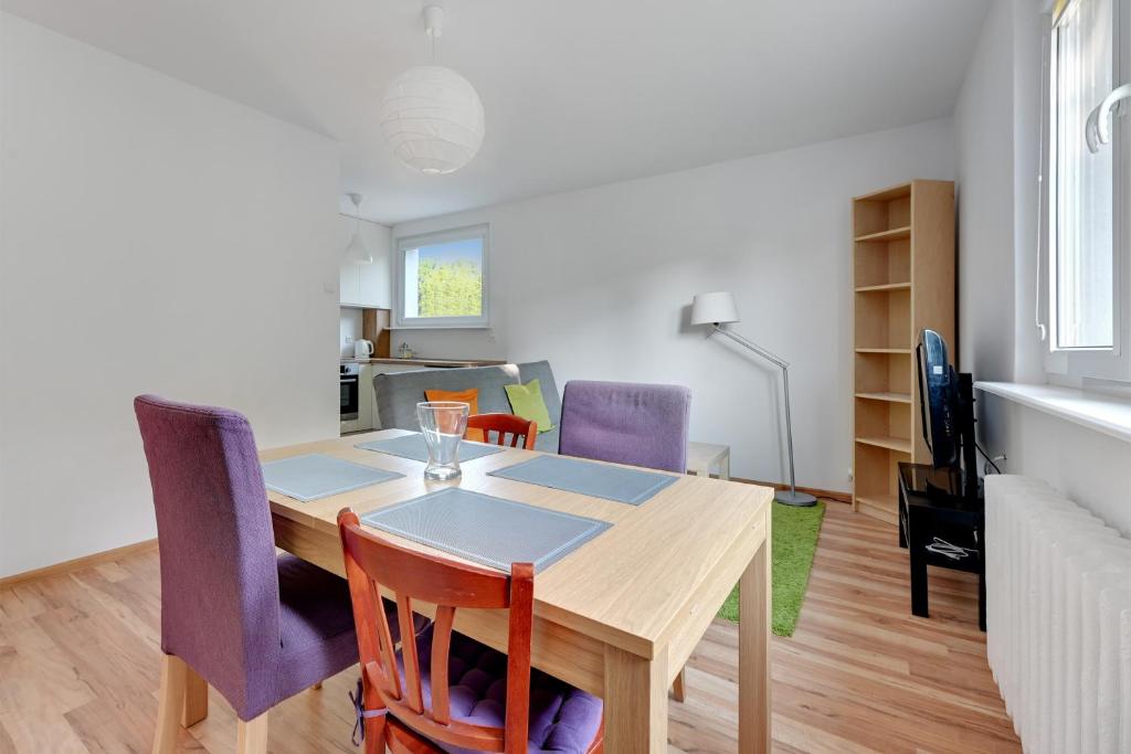 a dining room and living room with a table and chairs at Wave Apartments - Tysiąclecia in Gdańsk
