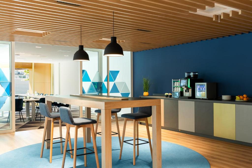 a kitchen with a wooden table and chairs at Holiday Inn Express Amsterdam - North Riverside by IHG in Amsterdam