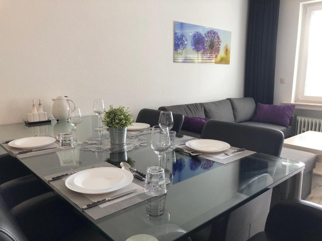 a dining table with plates and wine glasses on it at Apartment Anna-Eva in Winterberg