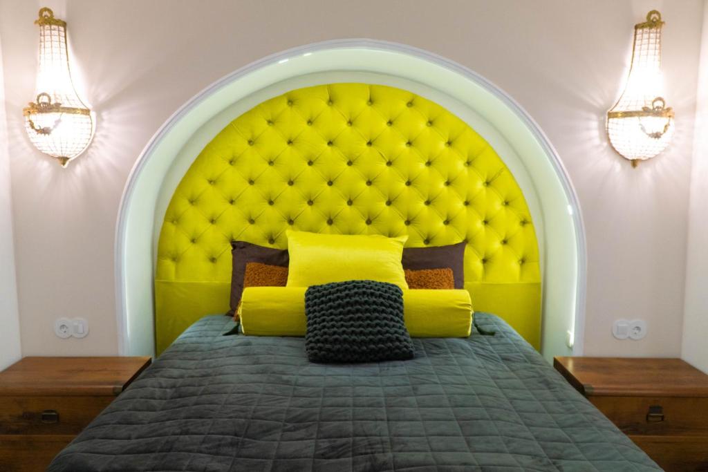 a bedroom with a yellow bed with a large headboard at Трирівневий лофт із спальнею-укриттям SELF Check-in 247 in Odesa