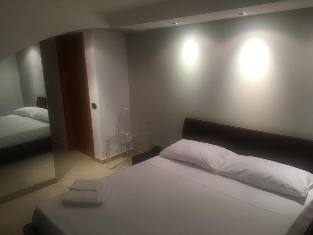 sypialnia z 2 łóżkami i 2 lampkami na ścianie w obiekcie TraMura w Trapani