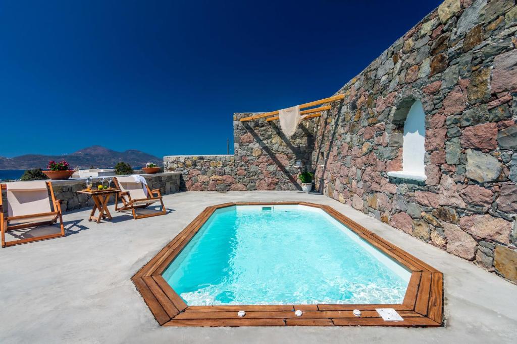a swimming pool in the middle of a stone building at Petra Residence Mini Pool Spa in Adamas