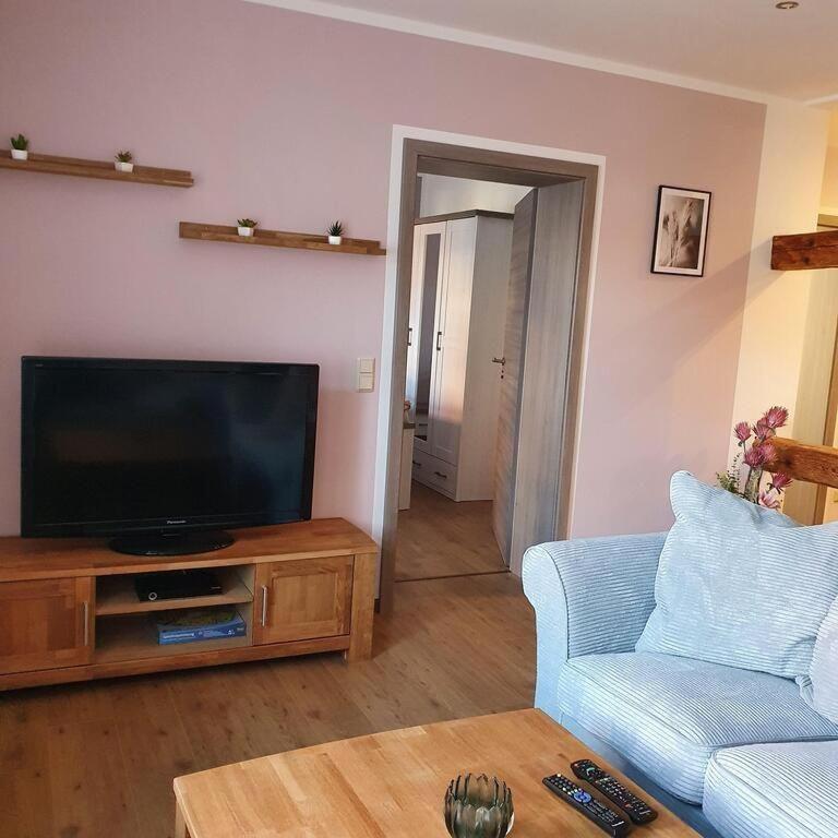 a living room with a television and a blue couch at Ferienwohnung-Am-Markt in Harzgerode