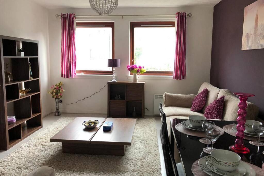uma sala de estar com uma mesa e um sofá em Beautiful Self-Catering 2 Bed Apartment with Free Parking 10 Minutes to City Centre em Edimburgo