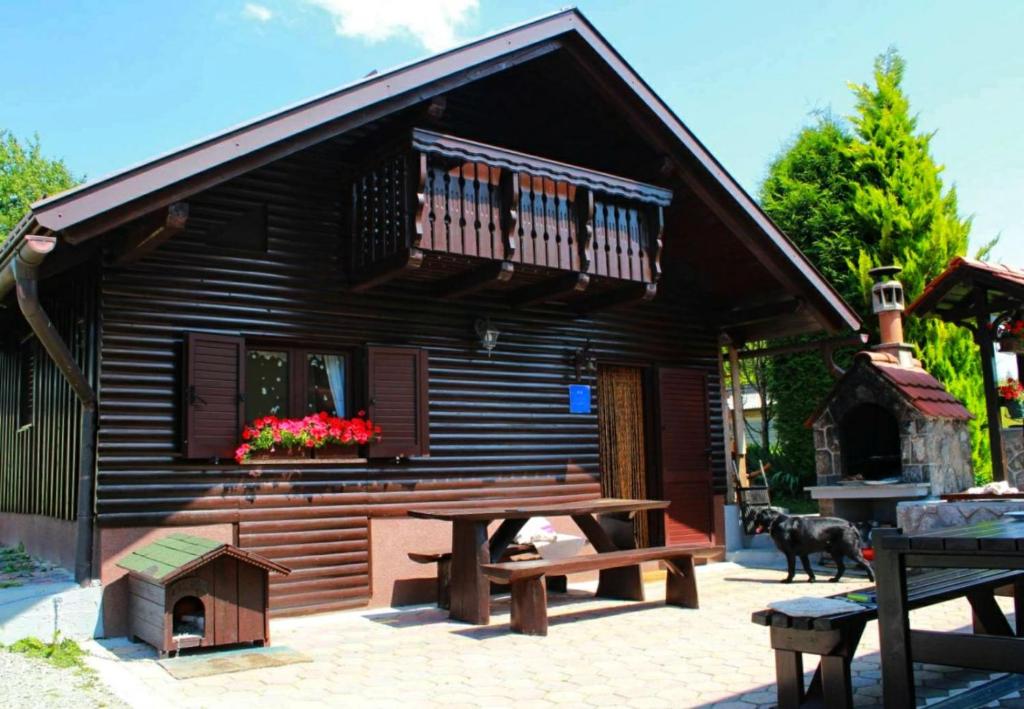 une cabane en rondins avec une table de pique-nique et un chien dans l'établissement NERRO, à Prezid