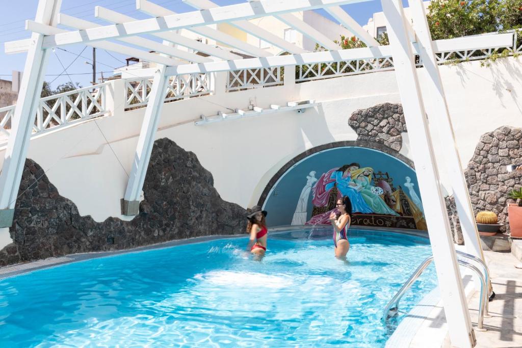 dos chicas en una piscina en un parque acuático en Erato Apartments, en Firostefani