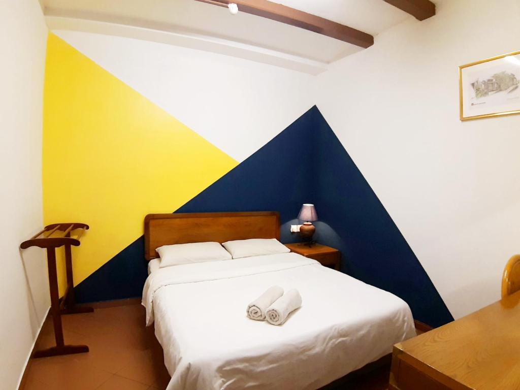 Postel nebo postele na pokoji v ubytování Heeren Inn Melaka