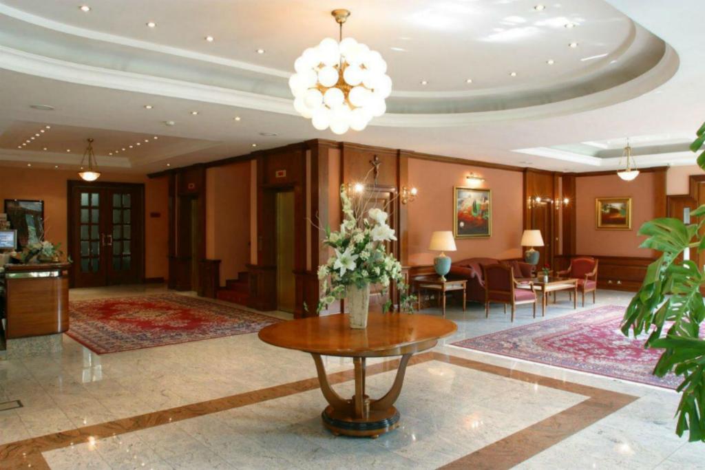 hol hotelu ze stołem i krzesłami w obiekcie Hotel AS w Zagrzebiu