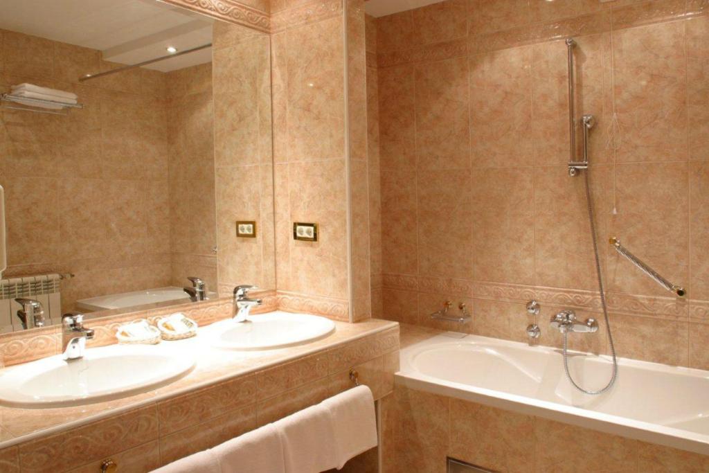 łazienka z 2 umywalkami, wanną i prysznicem w obiekcie Hotel AS w Zagrzebiu