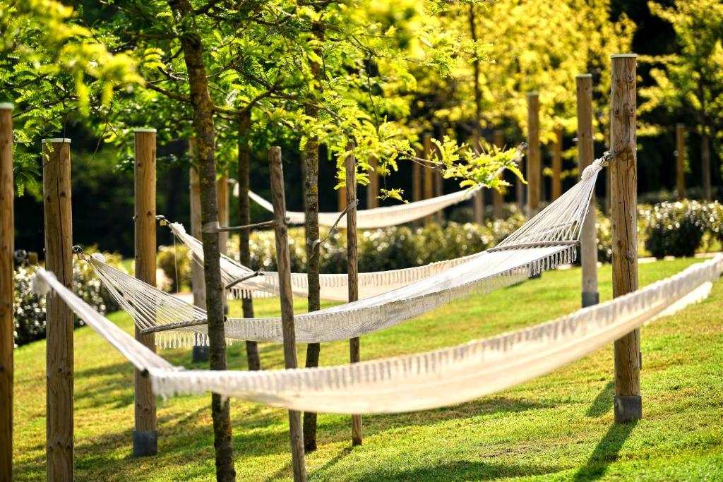 a row of swinging hammocks in a park at Hotel Mediteran Plava Laguna in Poreč