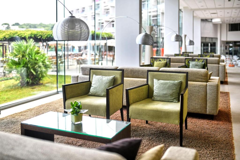 a lobby with couches and chairs and a table at Hotel Mediteran Plava Laguna in Poreč