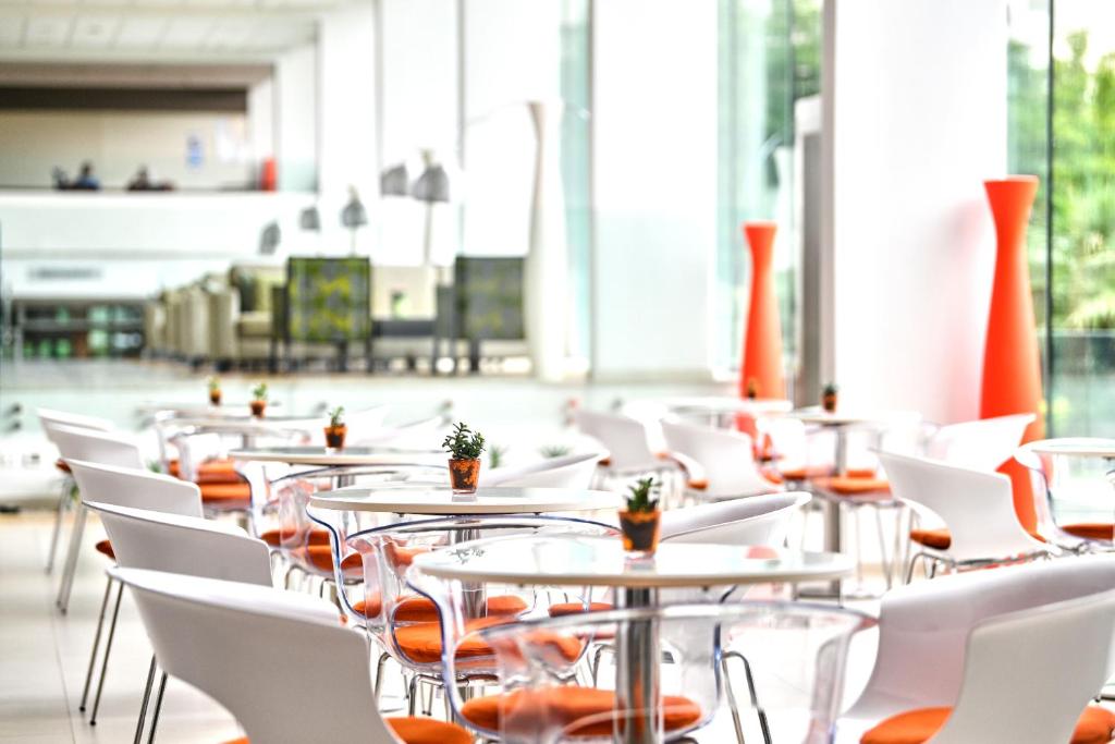 a row of tables and white chairs in a building at Hotel Mediteran Plava Laguna in Poreč