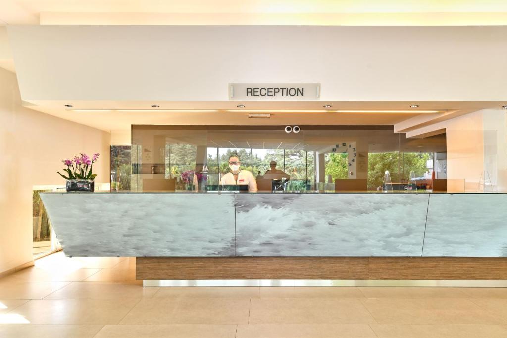 a lobby with a reception counter in a building at Hotel Mediteran Plava Laguna in Poreč