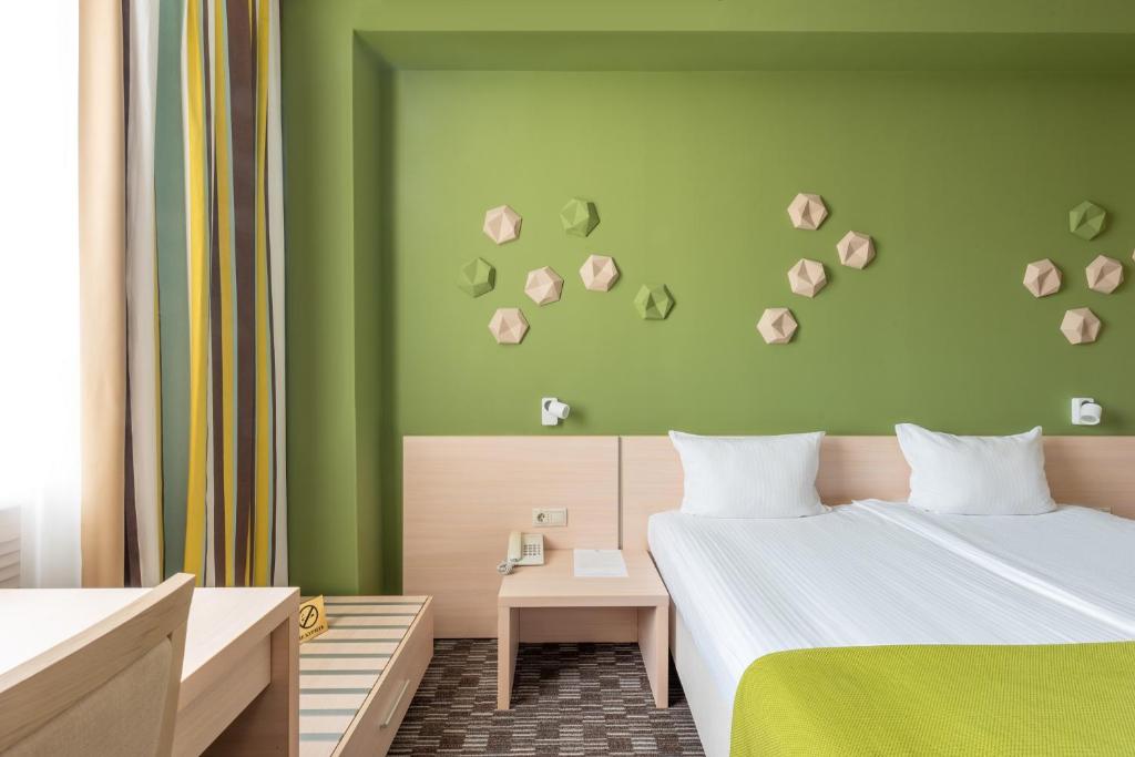 a bedroom with two beds and a green wall at Business Hotel Diplomat in Nizhny Novgorod