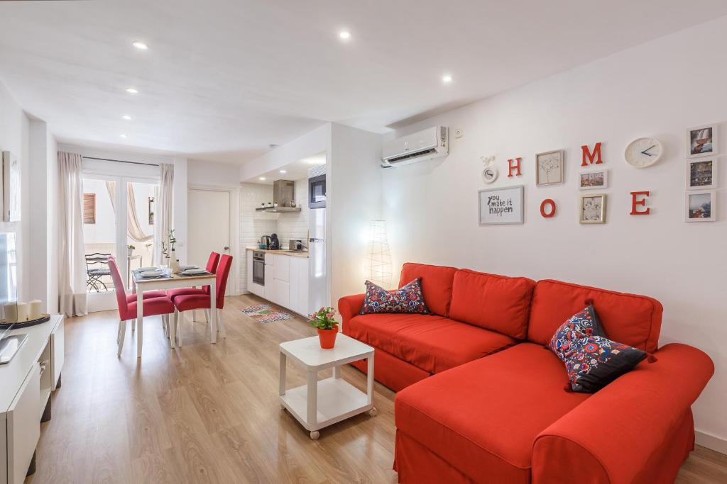 ein Wohnzimmer mit einem roten Sofa und einem Tisch in der Unterkunft Aire del Mar in Pollença