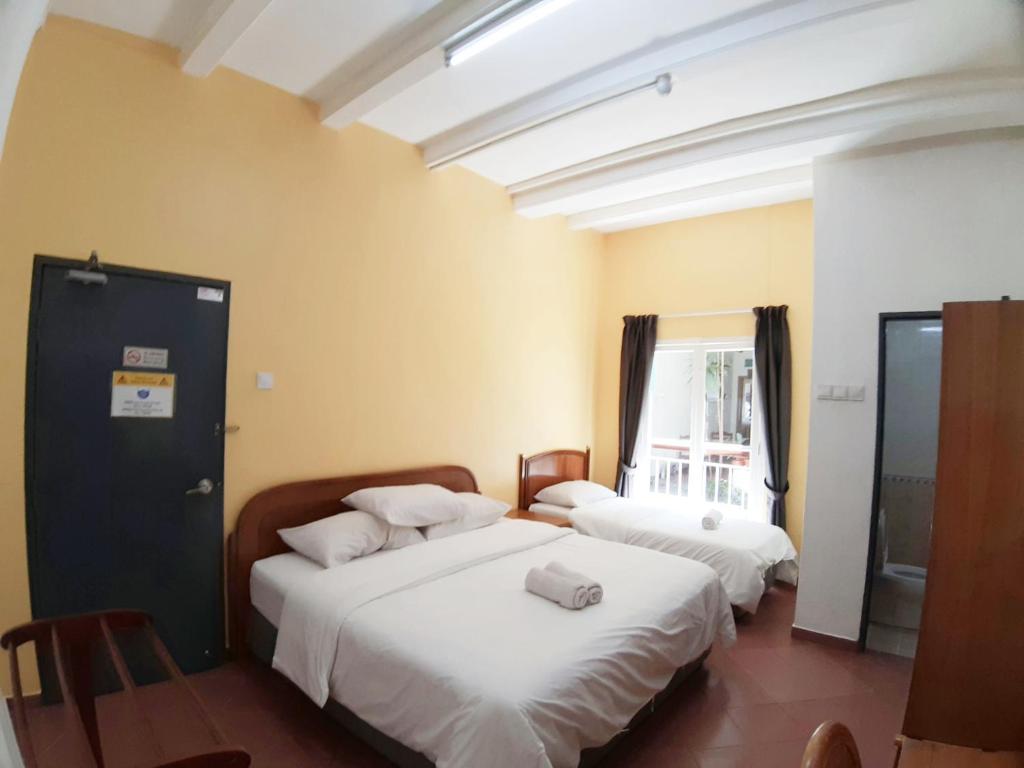 Postel nebo postele na pokoji v ubytování Heeren Inn Melaka