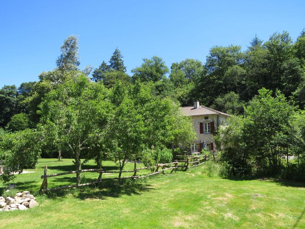 een oude boerderij met een hek en bomen bij Le Moulin de Pensol in Pensol