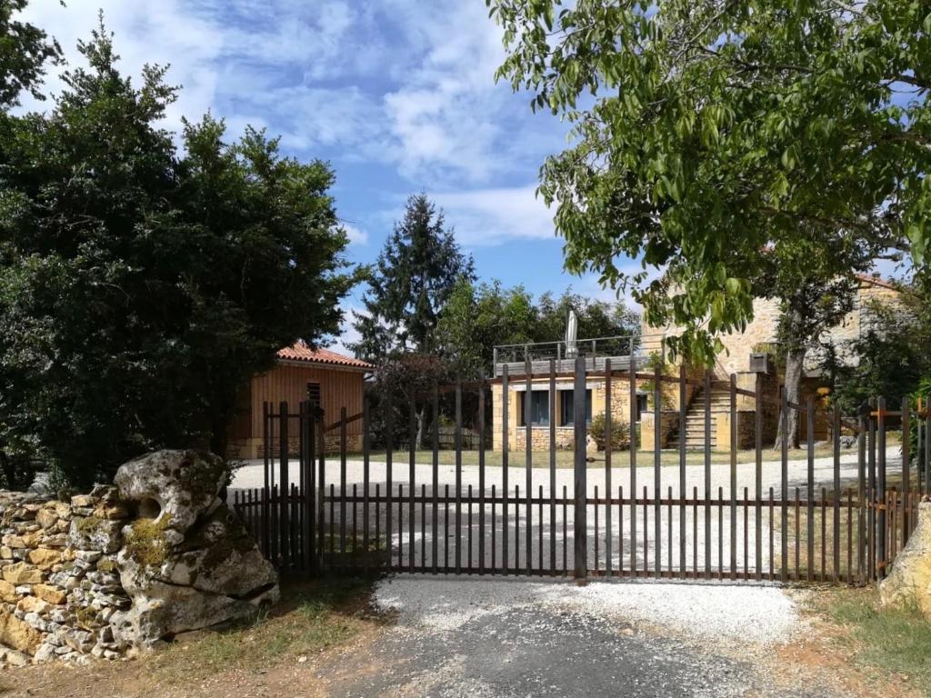 einen eisernen Zaun vor einem Haus in der Unterkunft Les Buis in Castelnaud-la-Chapelle