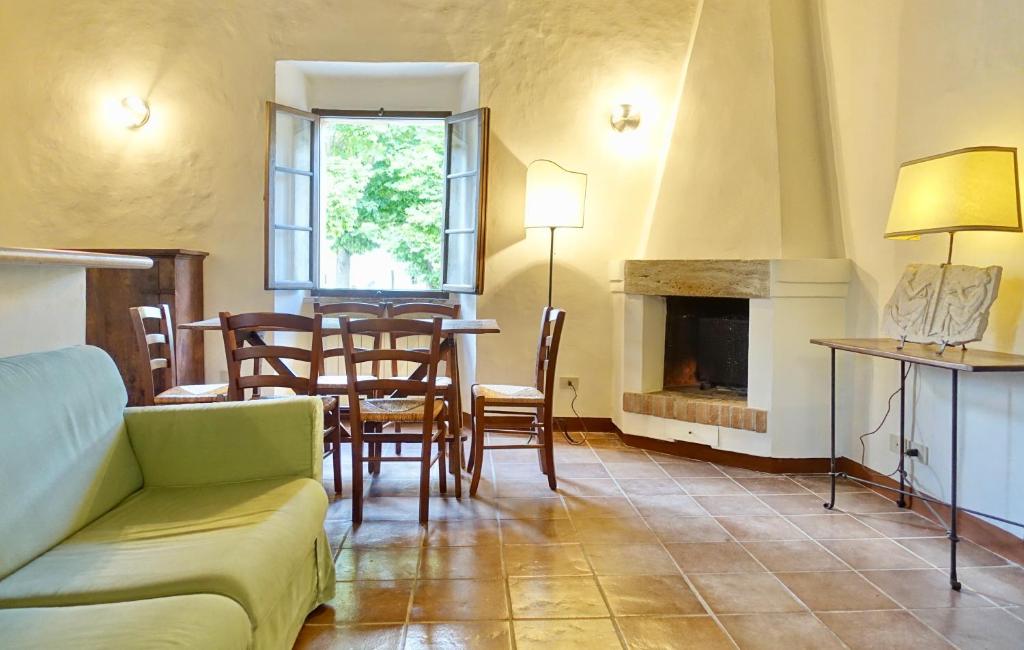 salon ze stołem i krzesłami oraz kominkiem w obiekcie Casa alla Vecchia Posta di Bagno Vignoni w mieście Bagno Vignoni
