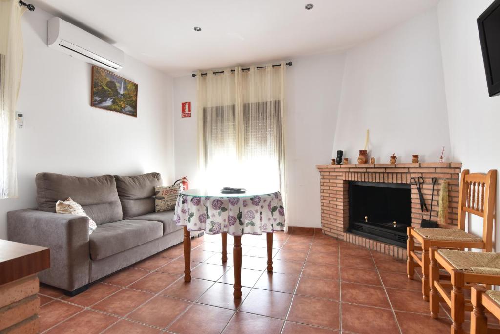 sala de estar con sofá y chimenea en El Rincón de Ramón, en Cortijos Nuevos