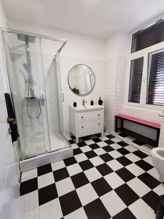a bathroom with a shower and a checkered floor at Litore in Pula