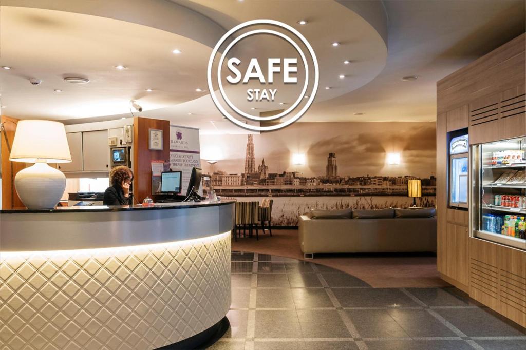 a woman sitting at a counter in a restaurant at Astoria Hotel Antwerp in Antwerp