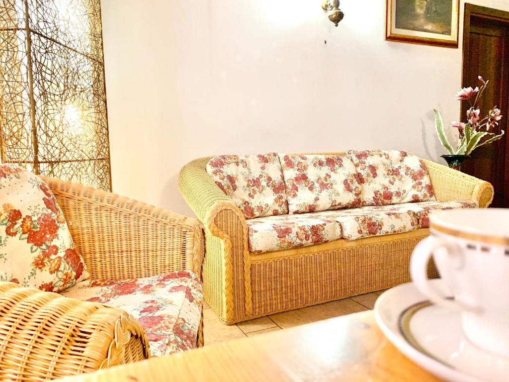 sala de estar con sillas de mimbre y sofá en Loft Florentia, en Prato