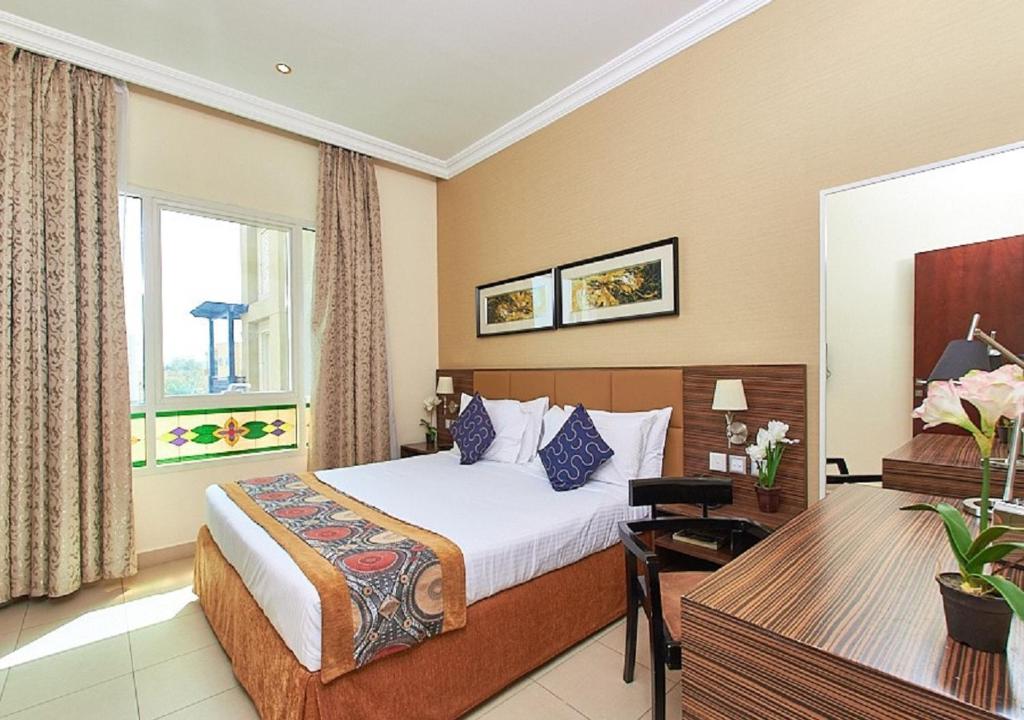 a hotel room with a bed and a desk at Mughal Suites in Ras al Khaimah