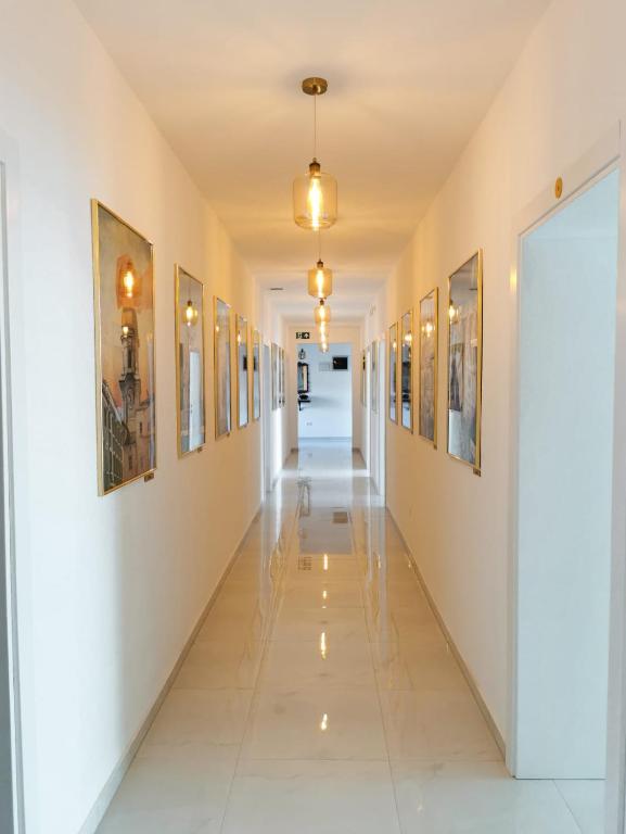 a corridor in a building with paintings on the walls at Litore in Pula