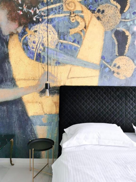 a bedroom with a bed and a wall with a painting at Litore in Pula