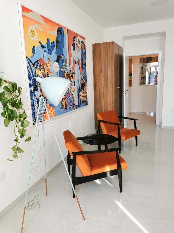 a room with two chairs and a table and a painting at Litore in Pula