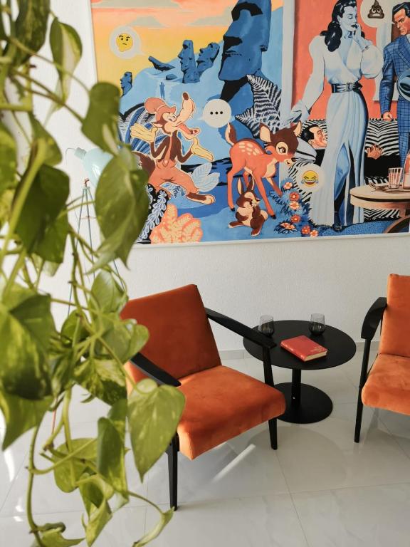 a living room with an orange chair and a painting at Litore in Pula