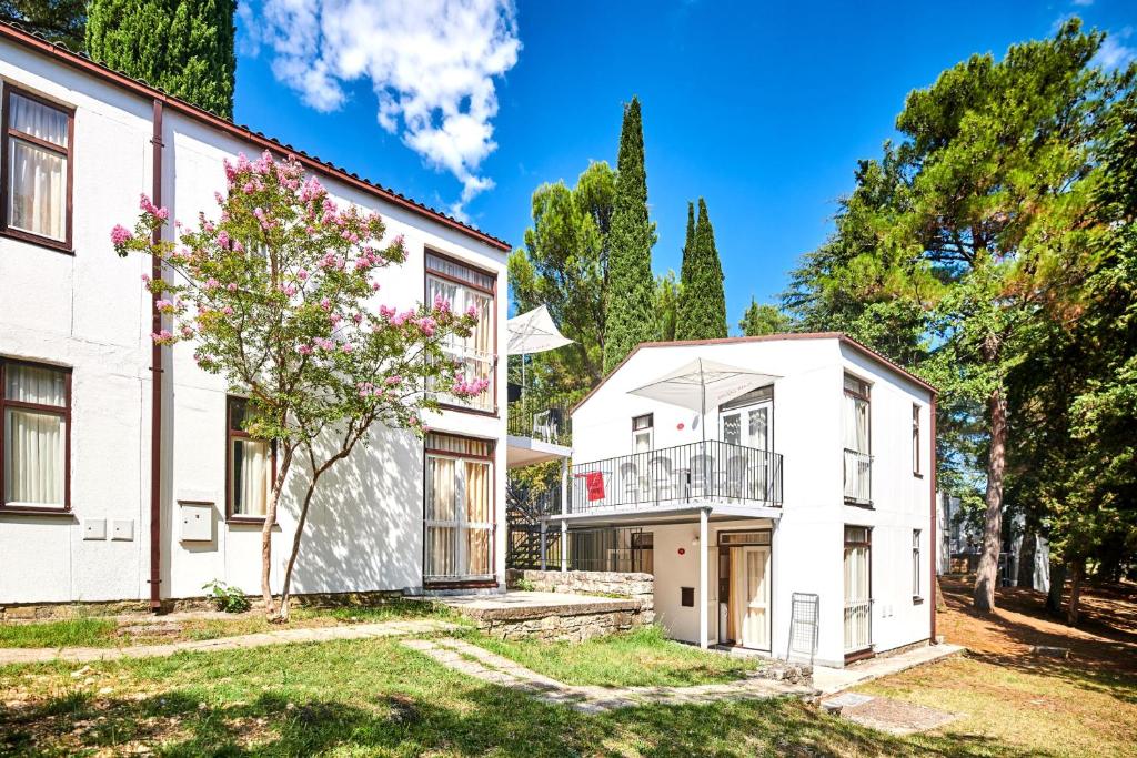 an exterior view of a white house at Apartments Astra Plava Laguna in Poreč