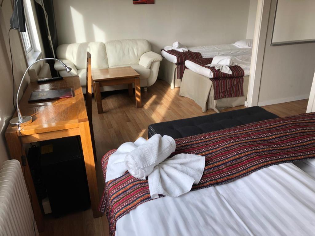 a hotel room with two beds and a living room at Motoristen in Vara