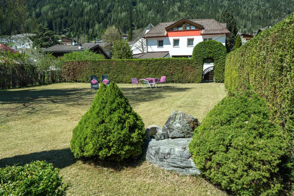 einen Garten mit zwei Bäumen und einem Felsen in der Unterkunft Appartement Pavillon in Fulpmes