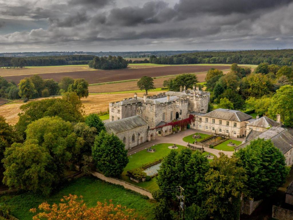 an aerial view of a large castle with trees at Hazlewood Castle & Spa in Tadcaster