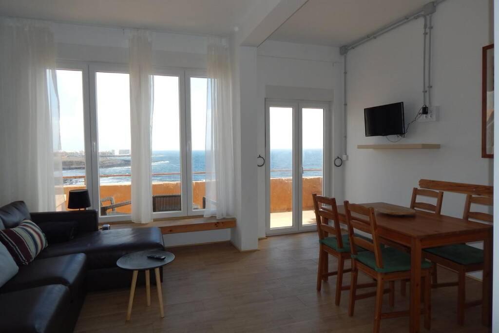 a living room with a couch and a table with a view of the ocean at Big, large cozy apartment with sea view ask for additional bedroom as an extra option in Telde